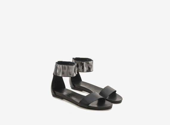 Sandale aus schwarzem Leder mit Metallplakette