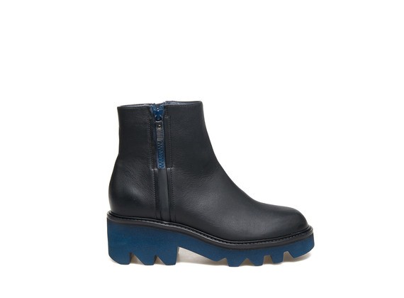 Black leather ankle boot with zip and blue rubber lug sole