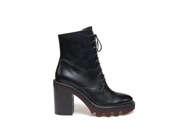 Black military boot with a contrasting rubber lug sole with heel