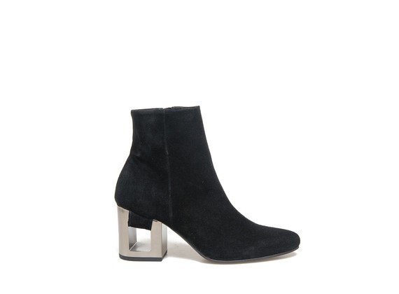 Ankle boot in black suede with band going through the perforated heel